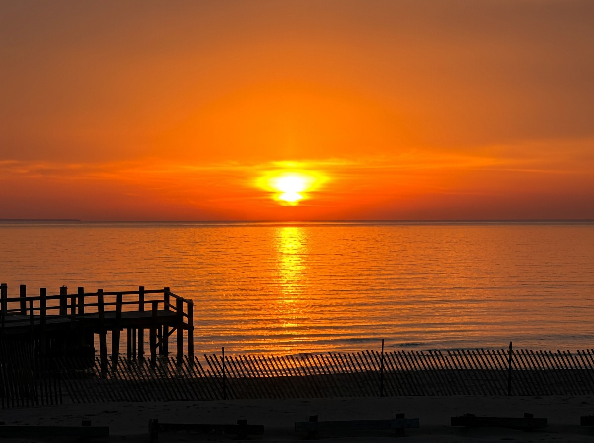 Vivid orange sunset over Lake Erie viewed from the Bayview outdoor patio at Turkey Point Beach